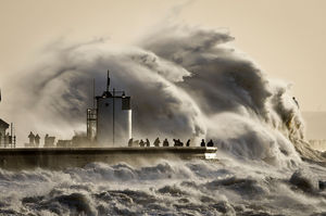People watch and photograph enormous waves as they break, on Porthcawl harbour, South Wales. Photo / AP