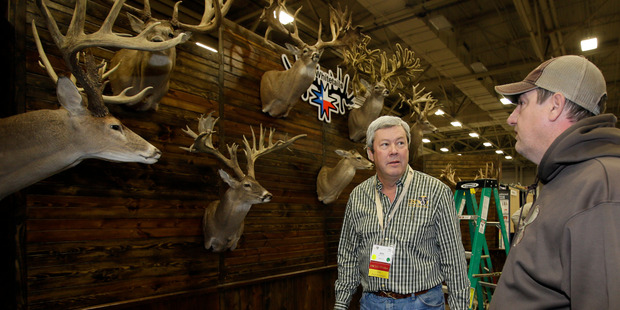 Dallas Safari Club executive director Ben Carter talks with Mike Woods of 4JM White Tails Hunting in the Dallas Exhibit Hall. Photo / AP