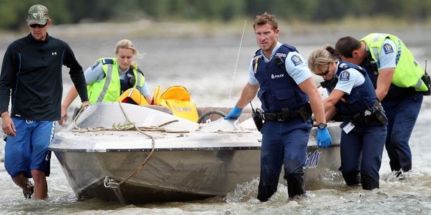 Police move the jetboat down river. Photo/Paul Taylor