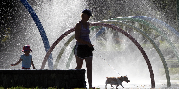 Genevieve Renall from Hastings with daughter Sarah Renall, 2, and Jess the dog, cooling off at Cornwall Park in Hastings yesterday, during 32C heat. Photo/Paul Taylor
