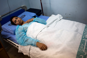 Nasser Ayoub, a 16-year-old student, lies on a hospital bed in Damascus, Syria. He was wounded by a mortar fire outside his school. Photo / AP