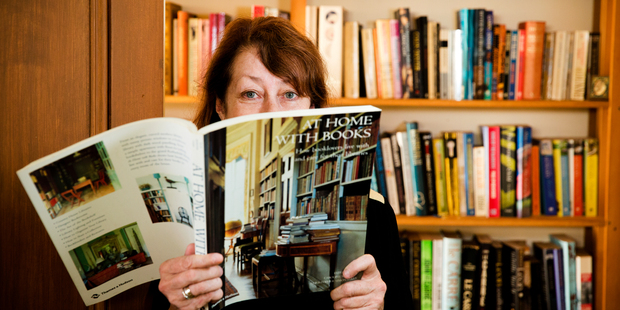 NZ Herald journalist Linda Herrick photographed at home with her library of books. Picture / Babiche Martens