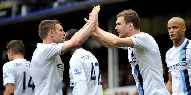 Manchester City's Edin Dzeko, right, celebrates with teammate James Milner after scoring the second goal of the game during their English Premier League soccer match against Everton. Photo / AP