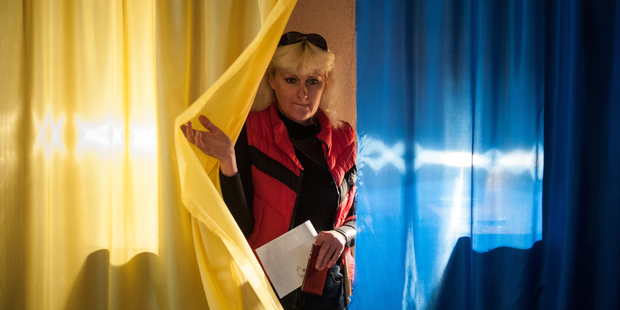 A local resident leaves a booth to cast her ballot at a polling station in Luhansk, Ukraine. Residents of Svatove are boycotting the referendum - despite threats. Photo / AP