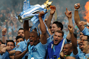 Manchester City's players captain Vincent Kompany, center, holds the Cup and celebrates with teammates after being crowned Premier League Champions, something many fans missed. Photo / AP