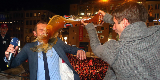 German TV presenter Markus Othmer, is sprayed with beer by Bayern Munich player Thomas Mueller. Photo / AP