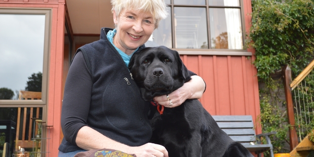 Helen Wilson at home today with her dog Coire, which was rescued after tumbling down a 4m abandoned mine shaft on Saturday morning. Photo / Greymouth Star