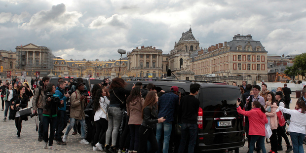 Fans look inside one of the cars for Kim Kardashian, Kanye West and their guests, at the entrance of the Chateau de Versailles in Versailles, France. Photo / AP