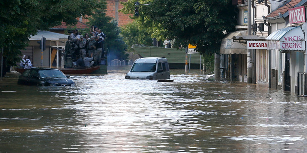 Evacuated people sit in the police vehicle leaving Obrenovac, some 30 kilometres southwest of Belgrade. Photo / AP