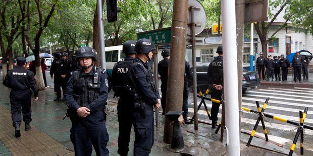 Armed policemen stand guard near the site of an explosion in Urumqi, northwest China's Xinjiang region. Photo / AP