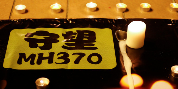 A banner is displayed during a candlelight vigil for passengers onboard the missing Malaysia Airlines Flight MH370, in Kuala Lumpur, Malaysia. Photo / AP