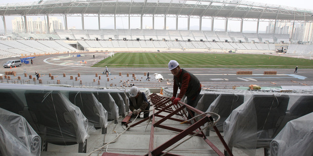 Laborers work at the main stadium for the 2014 Asian Games during a press preview in Incheon, South Korea. Photo / AP