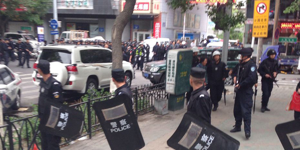 Police officers stand guard near a blast site in Urumqi, China. Photo / AP