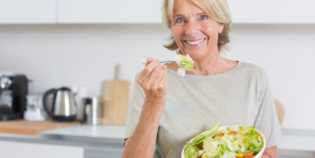 Smiling woman eating salad