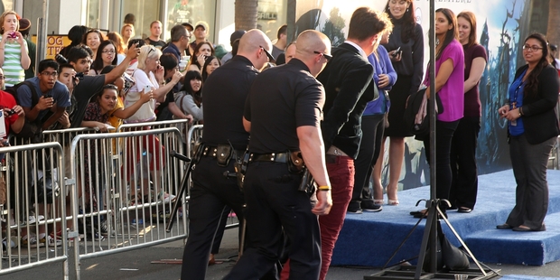 Vitalii Sediuk is led away in handcuffs after rushing Brad Pitt (far right) at the Hollywood premiere of Angelina Jolie's film Maleficent. Photo / AP