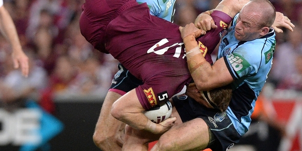 Brent Tate is cartwheeled by Josh Reynolds and Beau Scott at Suncorp on Wednesday night.Picture / Getty Images