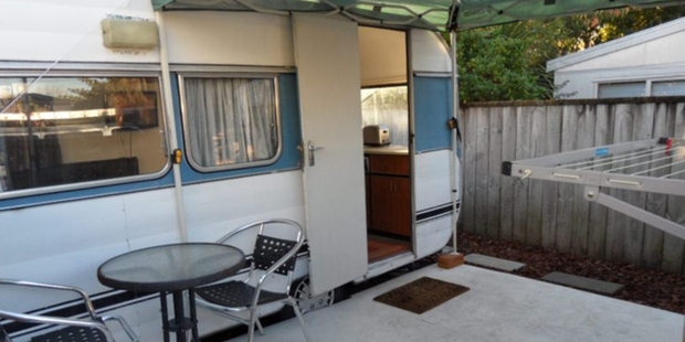The caravan for rent on Trade Me for $200 per week in Sandringham has a covered deck with a barbecue.