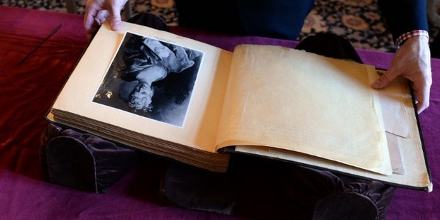 National Archives senior conservative Morgan Zinsmeister arranges the last known leather-bound 'Hitler Album' to display for a press conference at the National Archives in Washington, DC. Photo / AFP