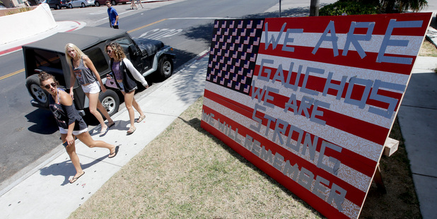 University of California, Santa Barbara students walks past a sign showing support for the college community. Photo / AP