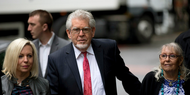 Australian born veteran TV and music entertainer Rolf Harris, center, arrives for his trial with his wife Alwen Hughes, right, and daughter Bindi. Photo / AP