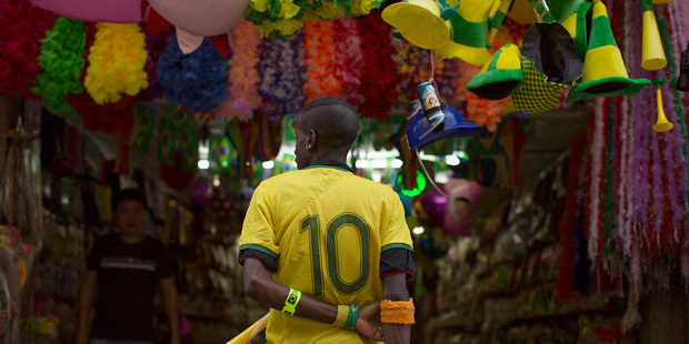 A vendor wears a Brazilian soccer jersey as he waits for customers in Rio de Janeiro, Brazil. Photo / AP
