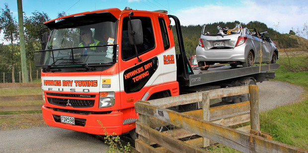 A tow truck removes a vehicle involved in fatal accident near Puketapu where an elderly couple's car left the driveway and rolled 30m into a tree. Photo/Warren Buckland