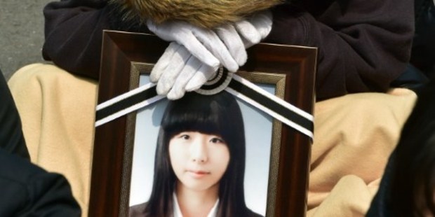 A family member holds a portrait of a teen who died in the Sewol ferry disaster. Photo / AFP