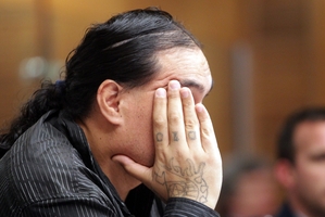 Murder accused Steven Tiwini Rakuraku tries to hide his face from cameras before he represented himself in court yesterday.