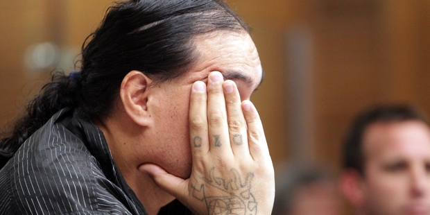 Murder accused Steven Rakuraku tries to hide his face from cameras before representing himself in court. Photo / Paul Taylor