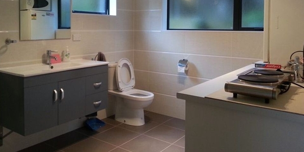 The toilet/shower/kitchen contravenes building and health and safety requirements in New Zealand.