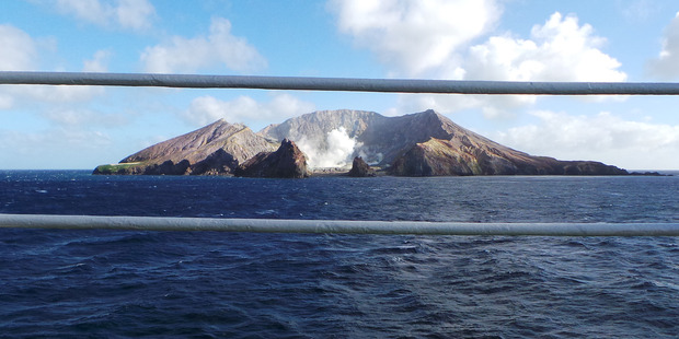 White Island viewed through the safety rail of a cruise ship. Photo / Winston Aldworth