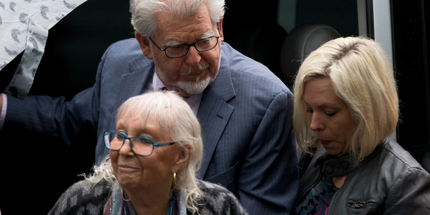 Veteran Australian-British entertainer Rolf Harris, center, his wife Alwen Hughes, bottom, and his daughter Bindi, right, arriving at court. Photo / AP