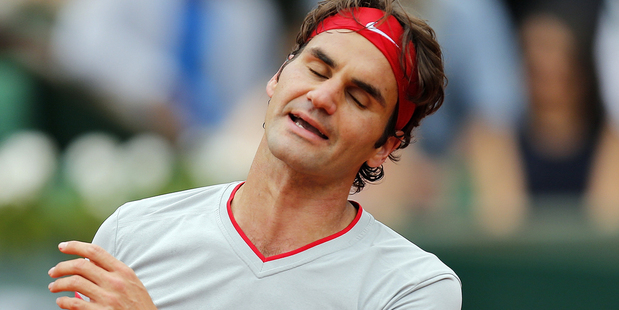 Roger Federer reacts after missing a return during the fourth round match of the French Open tennis tournament against Latvia's Ernests Gulbis. Photo / AP