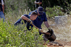 British policemen dig top soil with a shovel while searching for Madeleine McCann. Photo / AP