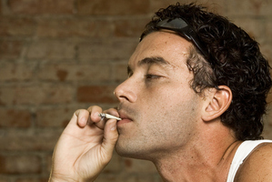 Side profile of a man smoking a joint