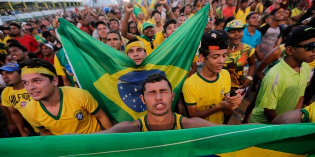 As crowds of Brazilian fans gather to watch the game, protesters destroyed a police car in a violent demonstration in Belo Horizonte.