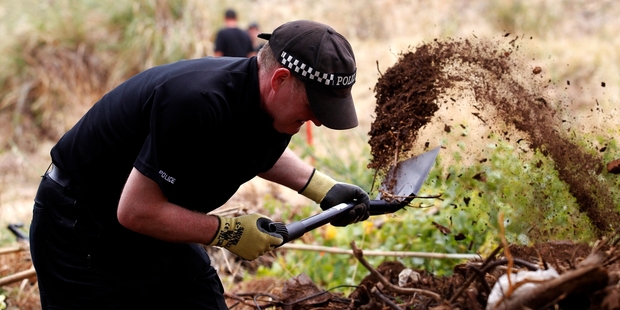 A British policeman digs in a cordoned-off area in Praia de Luz, Portugal.
