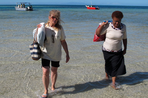 Volunteer Dana Satterfield and education programme coordinator Tema Savu wade to shore ahead of a day's teaching on Naviti Island. PHOTO / PETER DE GRAAF