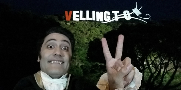 Taika Waititi, director and star of What We Do In The Shadows below the adapted "Vellington" sign.