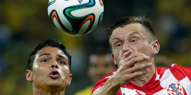 Wearing Nike shirts, Brazil's Thiago Silva, left, and Croatia's Ivica Olic battle for the adidas ball during the group A World Cup soccer match between Brazil and Croatia. Photo /AP