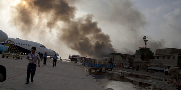 Smoke rises above the Jinnah International Airport in Karachi, Pakistan, where security forces continue to battle militants. Photo / AP