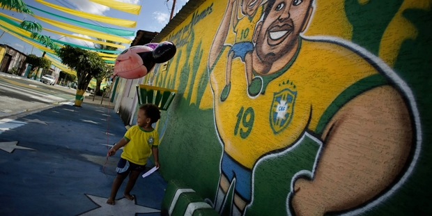 A child walks by a mural of Brazil's player Hulk in the Ceilandia suburb of Brasilia. Photo / AP