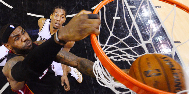 Miami Heat forward LeBron James dunks on San Antonio Spurs forward Kawhi Leonard. Photo / AP