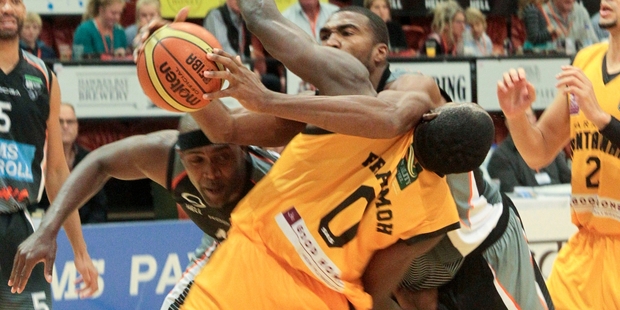 Kareem Johnson (left) and Dustin Scott tangle with Taranaki's Suleiman Braimoh.