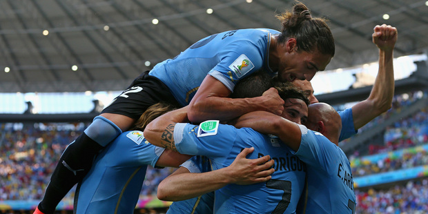 Players fall into each other's arms, forming a big sweaty pile of tattooed men, after scoring a goal during the 2014 FIFA World Cup, Brazil. Photo / Getty Images