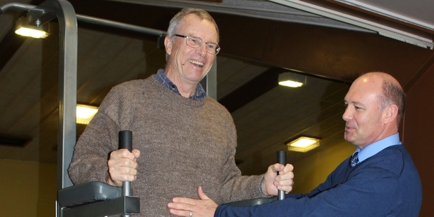 Dannevirke High School teacher Lloyd Parkes (left) tries out the multi-purpose abdominal exercise machine, aided by principal Dr Dawid de Villiers. Photo/Christine McKay
