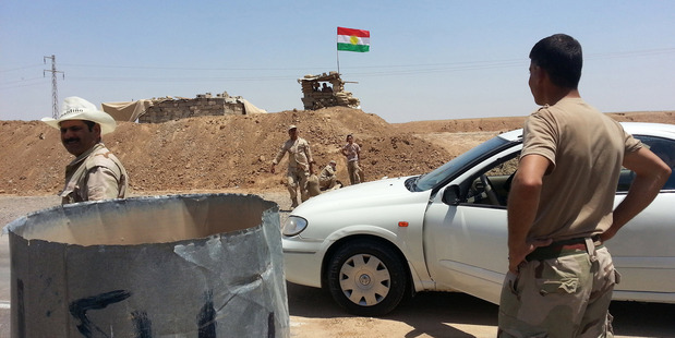 Kurdish security forces prepare combat positions while a Kurdish flag flies outside the oil-rich city of Kirkuk. Photo / AP