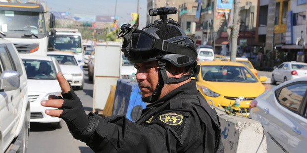 An Iraqi policeman stands guard at a checkpoint in Baghdad, Iraq. Photo / AP