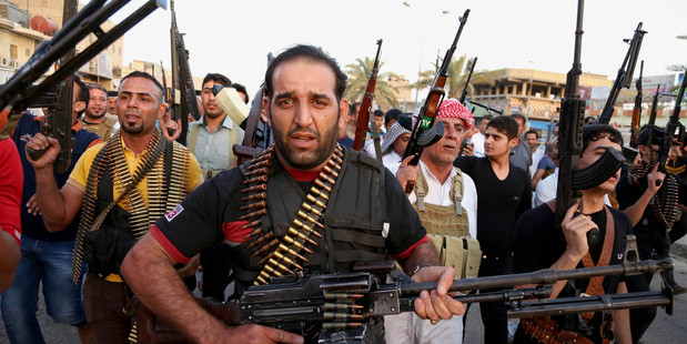 Iraqi Shiite tribal fighters deploy with their weapons while chanting slogans against the al-Qaida-inspired Islamic State of Iraq. Photo / AP