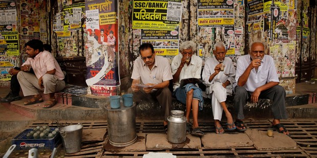 Indians sip tea sold by a wayside vendor in the morning in Allahabad, India. Photo / AP